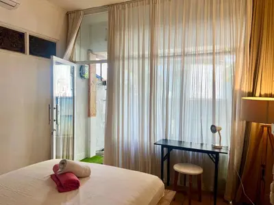 a bedroom with a bed and a desk and a window at Digital Nomad Oasis in Bali Calm, Cozy, Connected in Kerobokan