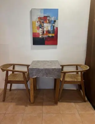 a table and two chairs in front of a painting at Digital Nomad Oasis in Bali Calm, Cozy, Connected in Kerobokan