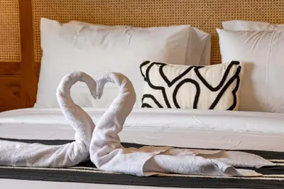 two towel swans are laying on a bed at A Better Villa 3BR Seminyak 5min Beach Bintang in Seminyak