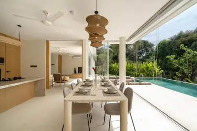 an open kitchen and dining room with a table and chairs at Villa Tiga by BaliSuperHost in Canggu