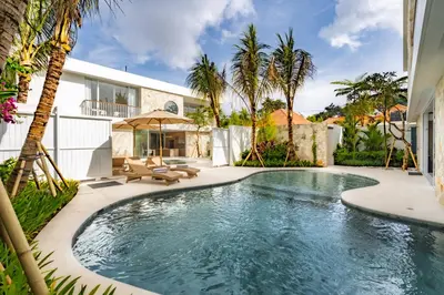 a swimming pool in a backyard with palm trees at Villa Twin 2 by BaliSuperHost in Canggu
