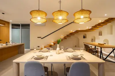 a dining room with a table and chairs and a staircase at Villa Twin 2 by BaliSuperHost in Canggu