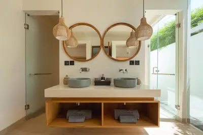 a bathroom with two sinks and two mirrors at Villa Nador Seminyak in Seminyak