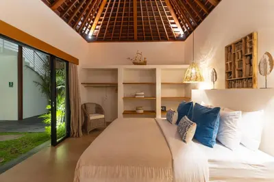a bedroom with a bed and a large window at Villa Nador Seminyak in Seminyak