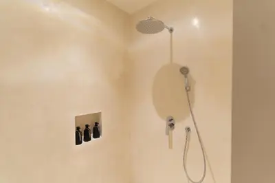 a shower with a shower head in a bathroom at Villa Nador Seminyak in Seminyak