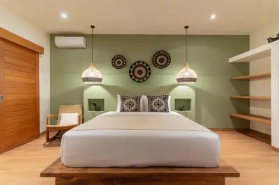 a bedroom with a large white bed and pendant lights at Villa Nador Seminyak in Seminyak
