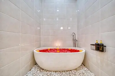 a bathroom with a tub with candles in it at Affordable 2 Bedroom Villa in Kerobokan with Private Pool in Kerobokan