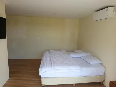 a bedroom with a bed with white sheets and pillows at villa reyray in Jimbaran