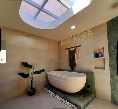 a bathroom with a large bath tub and a skylight at Joglo Raera Bali by Allura in Seminyak