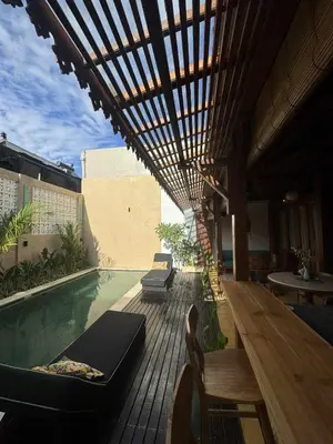 an outdoor patio with a pool and a table and chairs at Joglo Raera Bali in Seminyak