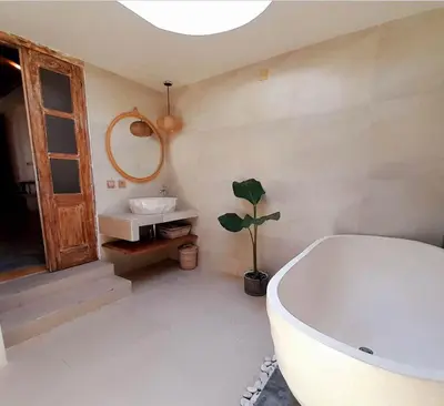 a bathroom with a bath tub and a sink at Joglo Raera Bali in Seminyak