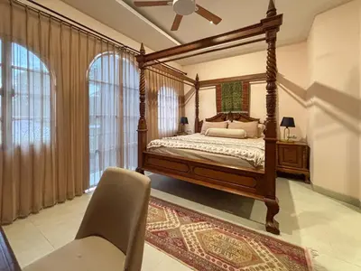 a bedroom with a canopy bed and a chair at The Lavana Villa Bungas near Nusa Dua in Jimbaran