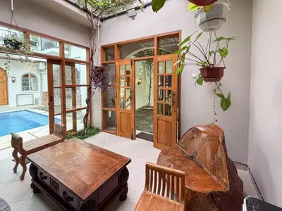 a living room with a table and chairs and a pool at The Lavana Villa Bungas near Nusa Dua in Jimbaran