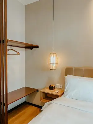 a bedroom with a bed and a table and a lamp at The Maru House in Seminyak