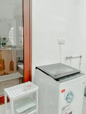 a kitchen with a white refrigerator and a table at The Maru House in Seminyak