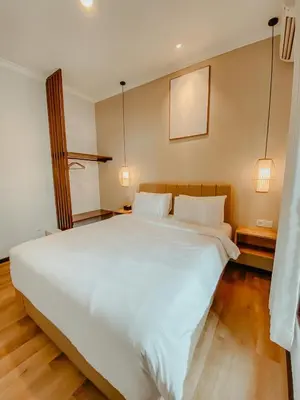 a large white bed in a room with two lamps at The Maru House in Seminyak