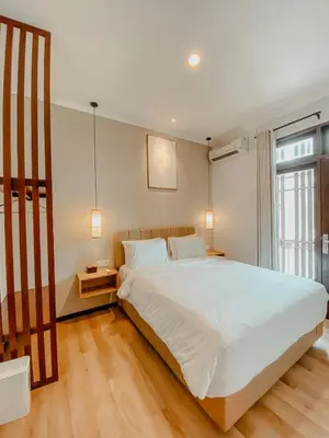 a bedroom with a large white bed and a window at The Maru House in Seminyak