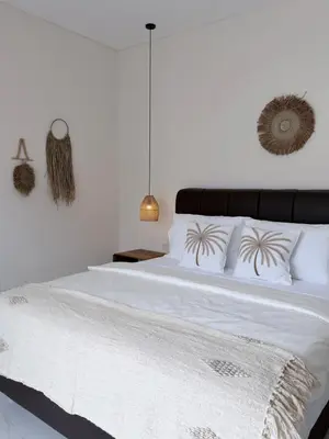 a bedroom with a large bed with white sheets and pillows at Villa Amore in Canggu
