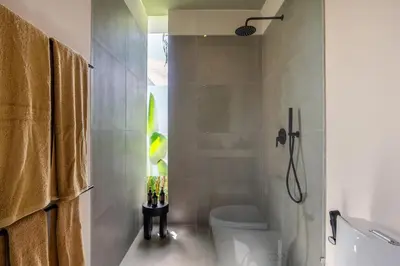 a bathroom with a shower and a toilet in it at Villa Knack, Seminyak in Kerobokan
