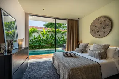 a bedroom with a bed and a television and a pool at Villa Knack, Seminyak in Kerobokan