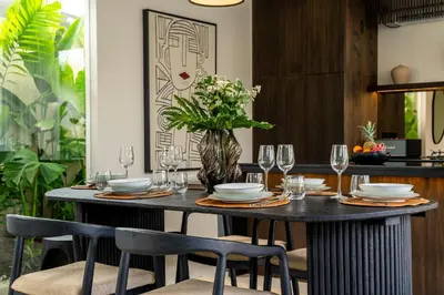 a table with plates and glasses and a vase with flowers at Villa Knack, Seminyak in Kerobokan