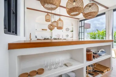 a kitchen with white shelves and pendant lights at Palm Sugar Villa - Stylish 3BR Retreat with Pool in Jimbaran