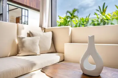 a white vase sitting on a table next to a couch at Palm Sugar Villa - Stylish 3BR Retreat with Pool in Jimbaran