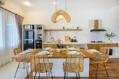 a kitchen with a large wooden table and chairs at Ondio Villa in Seminyak