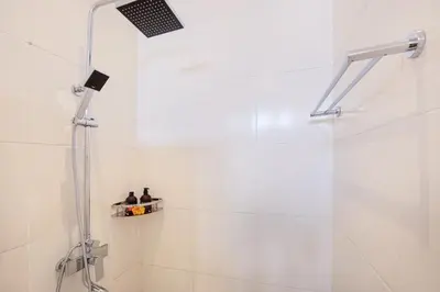 a shower with two bottles on a shelf in a bathroom at Ondio Villa in Seminyak