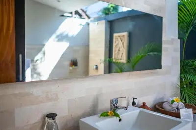 a bathroom with a sink and a mirror at Indira Peaceful 1 BR Private Pool Villa in Seminyak