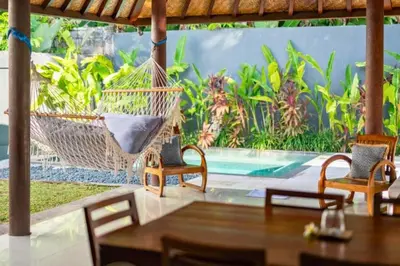 a porch with a hammock and a swimming pool at Indira Peaceful 1 BR Private Pool Villa in Seminyak