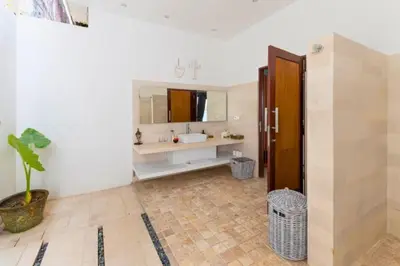 a bathroom with a sink and a mirror at Gahyaka Comfortable 2 BR Deluxe Private Pool Villa in Seminyak