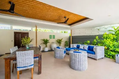 a patio with a wooden table and chairs at Gahyaka Comfortable 2 BR Deluxe Private Pool Villa in Seminyak