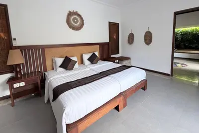 a bedroom with a large bed with white sheets at Alex Villa Bali in Seminyak
