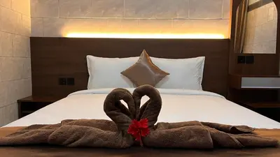 a pair of towels sitting on top of a bed at Tirta Suci Guest House in Ngurah Rai International Airport