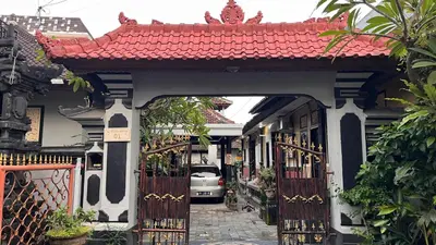 an entrance to a building with a gate and a car at Tirta Suci Guest House in Ngurah Rai International Airport
