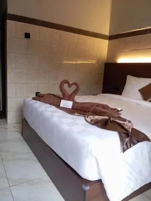 a bed with a blanket with a heart on it at Tirta Suci Guest House in Ngurah Rai International Airport