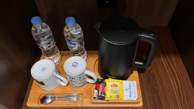 a table with two water bottles and a coffee maker at Tirta Suci Guest House in Ngurah Rai International Airport