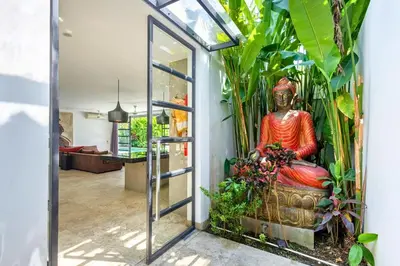 a door leading into a room with a statue of a buddha at Zen Retreat 3BR Japanese Inspired Oasis with Pool in Canggu