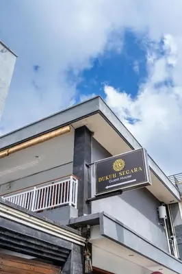 a sign on the side of a building at Collection O Dukuh Segara Guest House in Balian