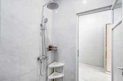 a shower with a glass door in a bathroom at Collection O Dukuh Segara Guest House in Balian