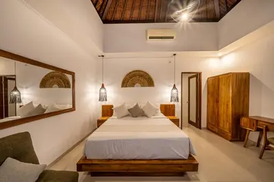 a bedroom with a large bed and a desk at Villa Melbourne in Seminyak