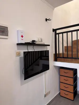 a living room with a microwave and a shelf on the wall at Cozy Minimalist Home Near Seminyak & Kuta in Seminyak