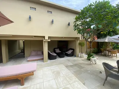 a patio with couches and a dog on a patio at arjuna house in Seminyak