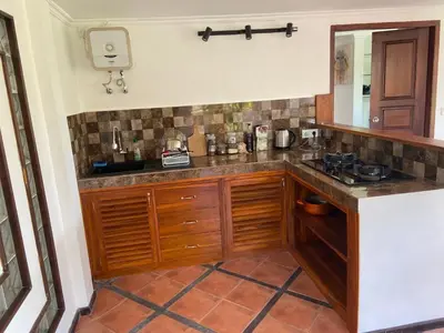 a kitchen with wooden cabinets and a counter top at arjuna house in Seminyak