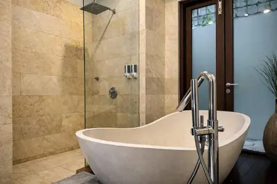 a bath tub in a bathroom with a shower at Jalina Private Villa in Central Seminyak in Seminyak