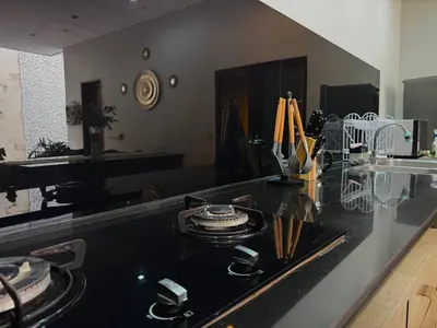 a kitchen with a black counter top with plates and utensils at Jalina Private Villa in Central Seminyak in Seminyak