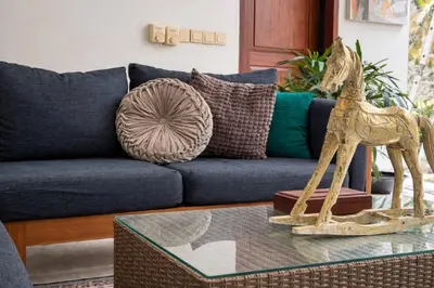 a living room with a blue couch and a table with a giraffe on it at Jalina Private Villa in Central Seminyak in Seminyak