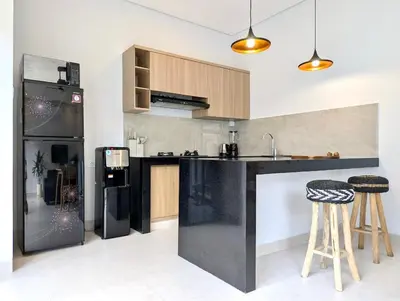 a kitchen with a black refrigerator and some bar stools at Brand new central Villa in Canggu