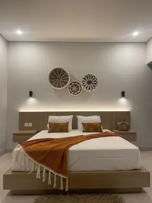 a bedroom with a large bed with two plates on the wall at Brand new central Villa in Canggu
